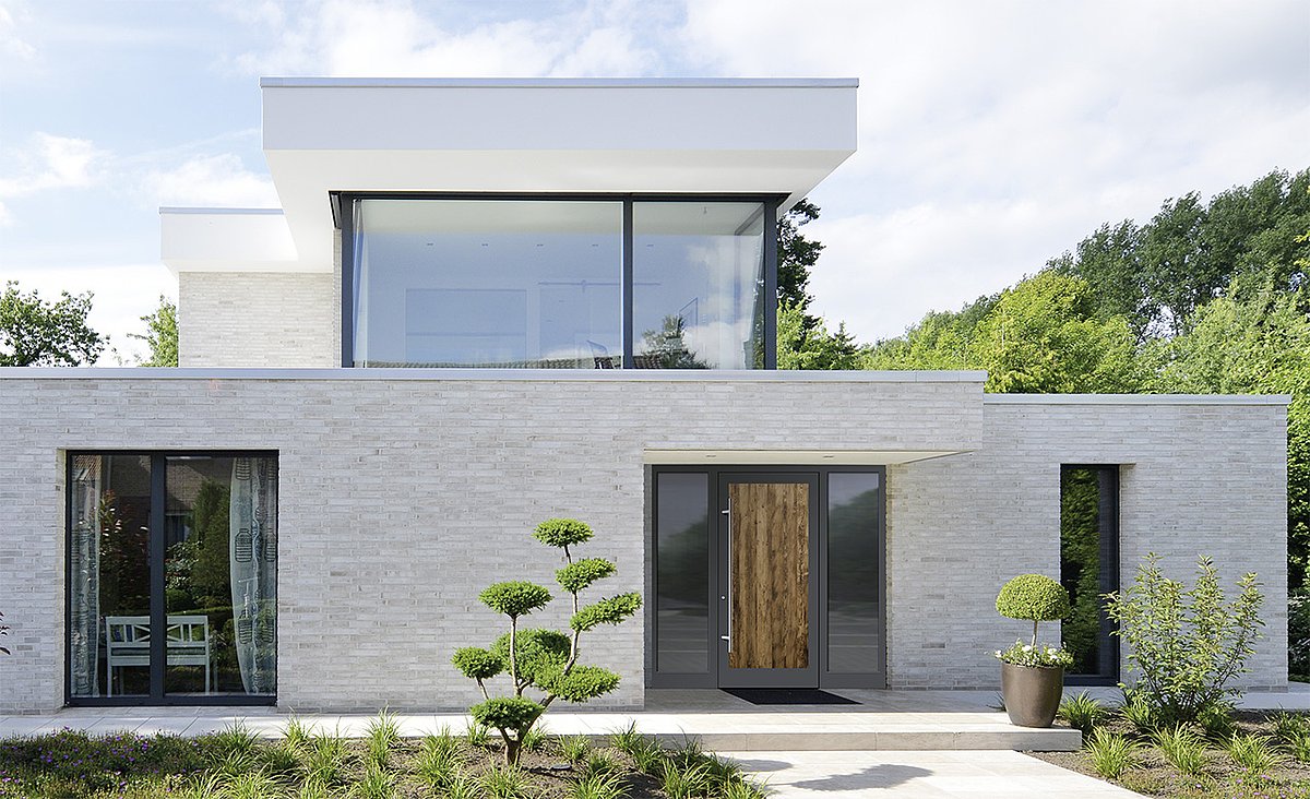 Puristisches Flachdachhaus im Bauhaus-Stil mit Haustür mit rauhem, offenporigem Fichtenholz